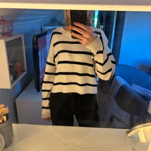 Randig stickad tröja - Säljer en mysig randig stickad tröja i svart och vit från Shein. Tröjan har en croppad passform och långa ärmar, perfekt för en avslappnad stil. Den är både bekväm och stilren, idealisk för kyligare dagar.💞