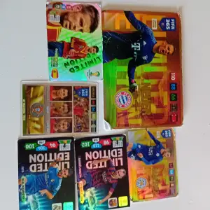 Samling av fotbollskort inklusive FIFA 365 och Limited Edition. Kort med spelare i olika positioner och lag, med färgglada bakgrunder och detaljerade spelarinformationer. Perfekt för samlare och fotbollsfans som vill utöka sin kollektion.