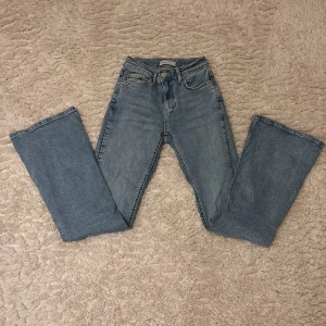 Ljusblå bootcut jeans från Gina tricot - Snygga ljusblå jeans från Gina tricot med klassisk femficksdesign och knappgylf. De har en bootcut passform och är perfekta för en avslappnad stil. Passar till allt i garderoben!
