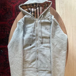 Grå Burberry Kofta - Grå Burberry Hoodie med zip. Storlek M. Nyskick, pris kan diskuteras!