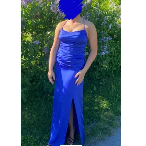 Blå långklänning med slits - Elegant blå långklänning med en stilren slits framtill och snörning i ryggen. Klänningen har en smickrande passform och är perfekt för speciella tillfällen. Jag är 160cm!