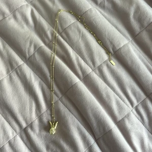 Halsband från Ioaku - Säljer ett elegant guldhalsband från IOAKU med en unik kaninberlock. Kedjan har små dekorativa kulor som ger extra stil. Det finns en liten knut på toppen men det är inget som syns. Det är ett långhalsband, en ioaku låda till kommer inte då jag inte fick en vid köp. Köpt på lyxxa