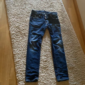 Blå jeans från Dsquared2 - Snygga blå jeans från Dsquared2 med en klassisk femficksdesign. De har en knappgylf och är tillverkade i en bomullsblandning för extra komfort. Perfekta för en stilren look.