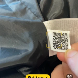 Svart dunjacka från Calvin Klein - Snygg svart dunjacka från Calvin Klein med dragkedja och bälte i midjan. Jackan har långa ärmar och en stilren design som passar perfekt för kyligare dagar. Använd 2 ggr och köpt för 3200 