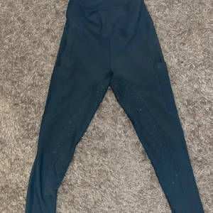 Zaczess ridbyxor - Snygga blå ridbyxor med hög midja och tight passform. Byxorna har praktiska fickor på sidorna och förstärkta partier för extra hållbarhet. Perfekta för ridning. Endast använda fåtal gånger så helt som nya. Lite färgat från sadeln men går bort i tvätten! Nypris ca 1000kr