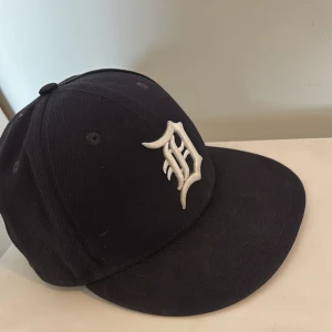 Svart keps från New Era - Snygg svart keps från New Era med broderad logotyp framtill. Kepsen är en del av 59FIFTY-serien och har en klassisk passform. Perfekt för att komplettera din streetwear-look. 