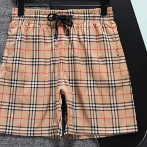 Rutig badshorts från Burberry - Snygga badshorts från Burberry i klassiskt rutigt mönster. De är beige med svarta och röda rutor och har en bekväm elastisk midja med snörning. Perfekta för en stilren look vid poolen eller stranden. Parfeckt in för våren/våren passar till alla outfits skriv för funderingar 😉