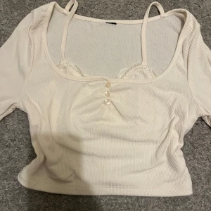 Långärmad tröja  - Säljer en söt beige/vit topp med långa ärmar och gulliga knappar framtill. Toppen har en layerd look som ger en y2k stil! Skriv vid frågor! 