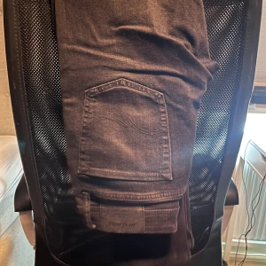 Svarta jeans från Jack & Jones - Snygga svarta jeans från Jack & Jones i slim fit. De har en klassisk femficksdesign och är tillverkade i ett bekvämt bomullsmaterial. Perfekta för en stilren look.
