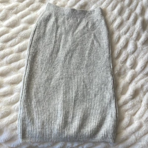 Grå ribbad kjol - Säljer en stilren grå ribbad kjol i mjukt material. Kjolen har en enkel design med elastisk midja och är perfekt för en avslappnad look. Passar bra till både vardag och mer uppklädda tillfällen. Passar både S som L. 