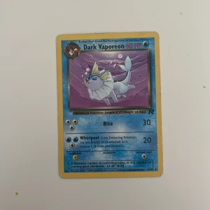 Dark Vaporeon - Coolt samlarkort med Dark Vaporeon från Pokémon! Perfekt för dig som gillar unika och nostalgiska kort. Kortet har en snygg illustration och är en favorit bland Pokémon-fans. Passar både samlare och spelare som vill utöka sin samling.