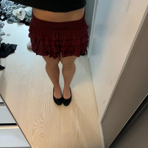 lågmidjad volankjol - superlågmidjad volankjol i vinröd. Helt ny med prislapp kvar. Köpt i London på subedued för 517kr. Kjolen har inbyggda shorts. Kom privat för fler bilder eller frågor!!❤️❤️