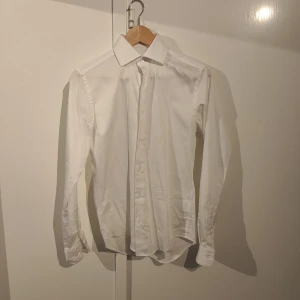 Kostym Dressmann - Klassisk vit skjorta från Dressmann i slim fit-modell. Samt svart kostym och kostym byxor från Dressman. Nytt pris 2000 kronor. Använd 1 gång