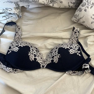 Intimissimi BH -  mörkblå bh med vackra ljusa spetsdetaljer och broderade blommor längs kanterna och axelbanden från Intimissimi. Storlek 80C