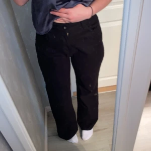 Svarta byxor med dragkedja - Säljer ett par svarta byxor i klassisk modell med normal passform och raka ben. Byxorna har dragkedja och knapp framtill. Perfekta till många olika outfits och enkla att matcha med andra plagg.