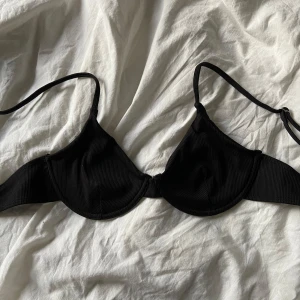 Bikinitopp - Säljer en svart ribbad bikini-topp med justerbara axelband i storlek S. Den är ovadderad. Jag säljer då den är för stor på mig. 