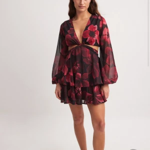 Blommig kort klänning från NA-KD. - Jättefin somrig klänning från NA-KD. Säljer pga har den i två storlekar. Alldrig använd, prislappen kvar!