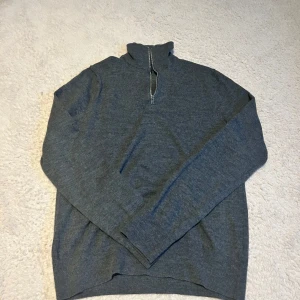 Grå merinoulltröja med half zip från Riley - Grå och snygg halfzip i mycket bra skick. Denna tröja är perfekt om du letar efter en lite mer slim typ av tröja. Denna tröja funkar perfekt på sommarkvällar då den är av den tunnare typen!