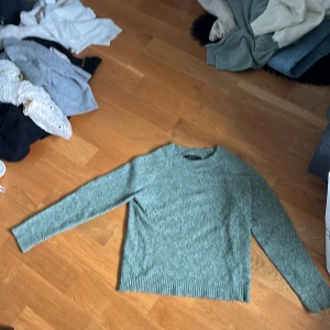 Grön stickad tröja från Vero Moda XS - Mysig ljusgrön stickad tröja från Vero Moda i storlek XS. Den är mer grön i verkligheten, man ser färgen på andra bilden . Tröjan har rund halsringning, långa ärmar och ribbade muddar vid ärmslut och nederkant. Perfekt för lager-på-lager och chill dagar.