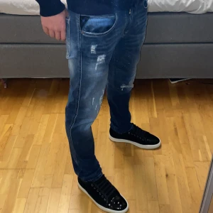 Replay anbass jeans - Tjena säljer dessa snygga mörkblåa replay anbass jeans i storlek 32/32. Jeansen är i modellen slim fit och har en unik och snygg tvätt med snygga slitningar. Skicket är 10/10, de är nya men lapparna är av och de har inga skador eller defekter. Jag på bilden är 176 och väger 62kg och de passar perfekt. Tveka inte att höra av dig om du har några frågor!