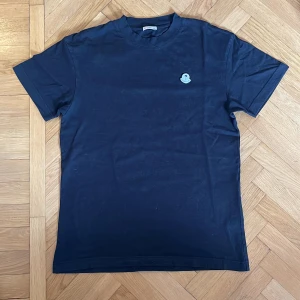 Moncler X Palm Angels t-shirt - En äkta Moncler x Palm Angels t-shirt, ordinarie pris 2620kr (kvitto finns). Köpt för 2,5 år sedan och använd ganska mycket men tröjan har hålt ett bra skick, inga synliga defekter förutom att bokstäverna på moncler loggan har blivit lite mindre synliga. Pris kan diskuteras.