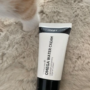The Inkey List Omega Water Cream - Omega Water Cream från The Inkey List är en lätt, återfuktande ansiktskräm i en vit och svart tub på 50 ml. Perfekt för dig som vill ha en återfuktad och fräsch känsla utan att huden känns fet. Passar alla hudtyper och är enkel att använda både morgon och kväll.