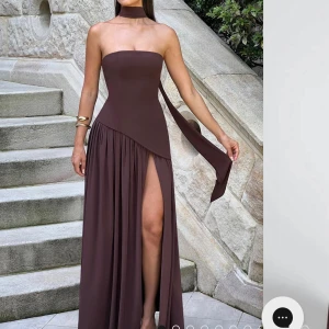 Brun klänning  - Säljer denna bruna maxi klänning i stl S. Scarf ingår. Snörning ibak man kan dra åt. Oanvänd. Lite liten i storleken. Köpt på babyboo fashion för ca 1800kr. Säljer pga köpte 2 storlekar. 