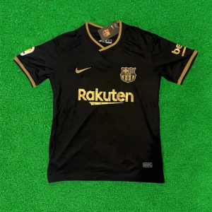 FC Barcelona svart fotbollströja Nike - Säljer en svart FC Barcelona fotbollströja från Nike med guldiga detaljer och loggor. Tröjan har korta ärmar, V-ringning och tryck från Rakuten och Unicef. Perfekt för dig som älskar Barca och vill sticka ut på planen eller läktaren.
