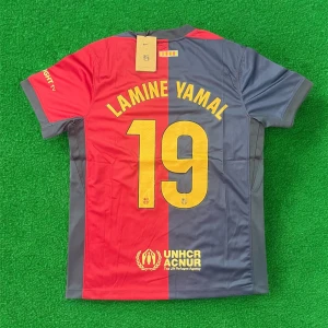 FC Barcelona fotbollströja Lamine Yamal 19 - Säljer en officiell FC Barcelona matchtröja med Lamine Yamal och nummer 19 på ryggen. Tröjan är röd och blå med gula detaljer, Nike-logga och klubbmärke på bröstet samt Spotify som sponsor. Kortärmad modell i lätt och ventilerande material.