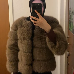 Brun pälsjacka  - Säljer en fluffig brun pälsjacka i syntetmaterial. Jackan har lång ärm och är designad i breda, horisontella sektioner för en extra voluminös look. Perfekt för dig som vill sticka ut med en trendig och varm jacka. ✨🤎