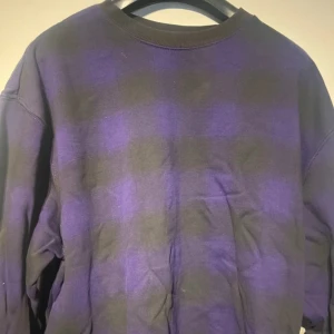 Lila och svart rutig sweatshirt Weekday - Säljer en oversized sweatshirt från Weekday i storlek M. Tröjan har ett rutigt mönster i lila och svart, rund halsringning och långa ärmar. Tillverkad i mjuk bomull, perfekt för en chill och avslappnad stil.