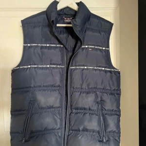 Tommy Hilfiger väst - Säljer nu denna stilrena Tommy Hilfiger västen, väldigt sparsamt använd. Storlek M-176 