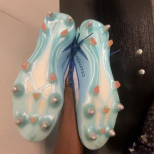 Adidas Crazyfast blå fotbollsskor  - Säljer ett par Adidas Crazyfast fotbollsskor i blått med vita detaljer och snörning. Skorna har metall- och plastdobbar för gräsplan, meshpaneler för ventilation och en sportig look. Perfekta för dig som vill ha snabba fötter på planen.