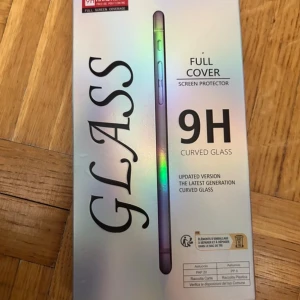 Skärmskydd  - Bilderna visar ett skärmskydd av härdat glas för iPhone 14 Plus, inte en bok. Produkten är designad för att skydda din mobilskärm mot repor och stötar med 9H hårdhet och full täckning. Perfekt för dig som vill hålla mobilen fräsch och snygg längre.
