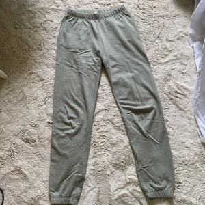 Gröna mjukisbyxor från ONLY XS - Snygga ljusgröna mjukisbyxor från ONLY i storlek XS. De har resår i midjan och vid bensluten för en skön passform. Perfekta för chill dagar eller när du vill vara bekväm. Tillverkade i mjukt bomullsmaterial. Tyvärr en liten fläck vid de ena knäet. Annars super skick! 