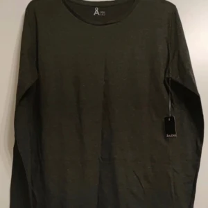 långärmad tröja  - Säljer en helt ny och oanvänd långärmad tröja från Åhléns. 📏 Storlek: M 🌑 Färg: Mörkgrå 🎀 Prislappen sitter kvar (utan angivet pris) 💯 Aldrig använd  En stilren och bekväm baströja – perfekt för höst och vinter!