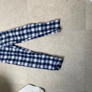 Blårutiga mjukisbyxor i bomull - Mysiga mjukisbyxor med blåvitt rutigt mönster och resår i midjan. Perfekta för chill dagar hemma. Tillverkade i mjuk bomull som känns skön mot huden.