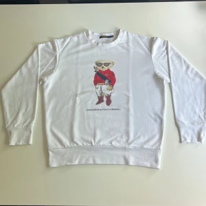 Vit sweatshirt Polo Ralph lauren  - Vit sweatshirt från Polo Ralph lauren med ikoniskt Polo Bear-tryck på bröstet. Tröjan har rund hals, långa ärmar och är gjord i mjuk bomull. Storlek S, Har aldrig använts 
