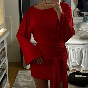 Röd klänning med knytdetalj - Röd klänning från Gina Tricot med knytdetalj.