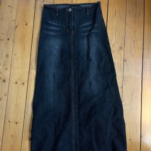 Mörkblå lång jeanskjol från Jeans West - Säljer en snygg mörkblå lång jeanskjol från Jeans West. Kjolen har klassiska jeansdetaljer som synliga sömmar, knapp och hällor för bälte. Rak passform med lätt utsvängd nederdel, perfekt till sneakers eller boots.                                                    Pris går att diskutera 🫶🏼
