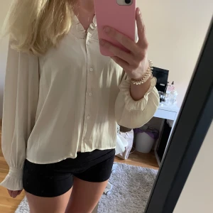 Offwhite blus i satin från Neo Noir - Säljer denna super gulliga blusen som fortfarande har prislappen kvar, den är helt oanvänd och i nyskick💕pris går såklart att diskuteras💖