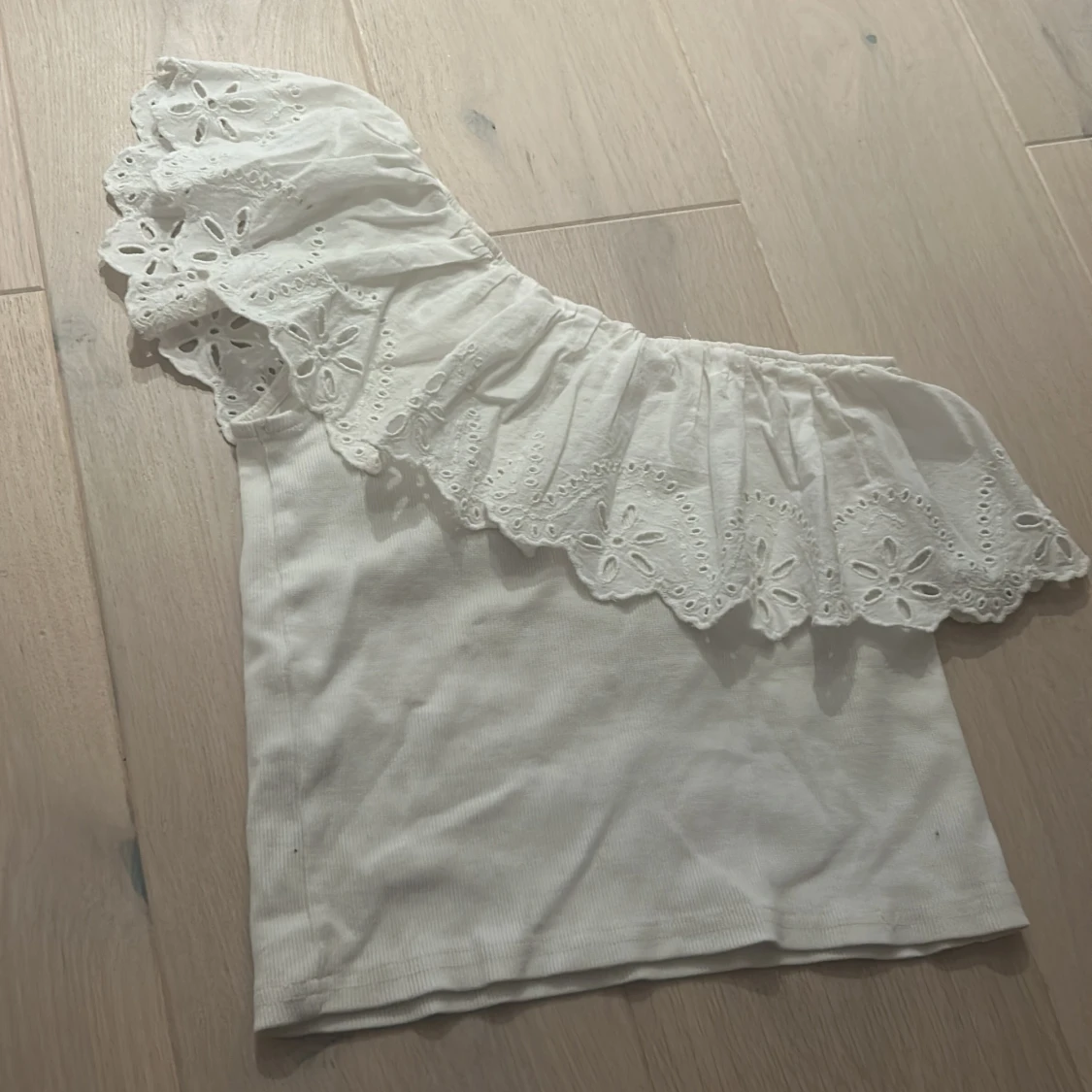 Vit oneshoulder topp med volang