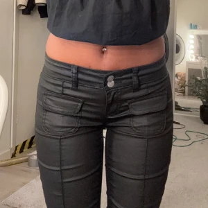 Svarta bootcut byxor med fickor - Säljer ett par svarta bootcut byxor med snygga fickdetaljer framtill och dubbla knappar i midjan. Skickar fler bilder och mått vid intresse!😊❤️