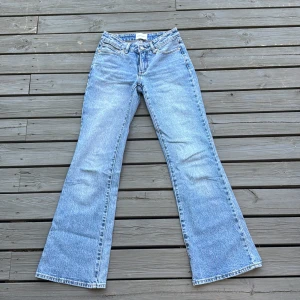 Blå bootcut jeans från Abrand - Säljer ett par klassiska ljusblå Abrand jeans med bootcut passform. Jeansen har låg midja, fem fickor och är tillverkade i slitstarkt denim. Perfekta för dig som gillar retrovibbar och vill ha ett par snygga jeans med utsvängda ben. Midjemåttet är 35 cm och innerbensmåttet är 75cm ❣️Nypris 1200kr