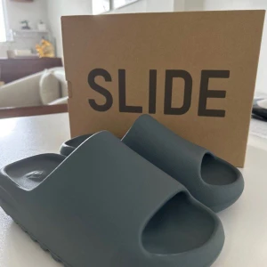 Yeezy slides slate gray - Yeezy Slide “slate gray” – Strl 44 1/2 (US 10 / UK 10) ✅ Äkta vara – har tags men ej kvitto 🧼 Mycket gott skick – helt ny o oanvänd.  📦 Originalförpackning medföljer   ⚠️ Säljes p.g.a. fel storlek 📍 Möts upp i Göteborg eller skickas spårbart  Skriv om du har frågor eller är intresserad. PRIS KAN DISKUTERAS