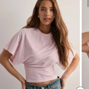 Rosa T-shirt - Supersöt slutsåld  rosa tröja från Nelly, alldrig andvänd då jag tyvärr inte har fått någon andvändning av den. Den är kroppad där nere och lös där uppe. Hör av er om ni har några funderingar❤️