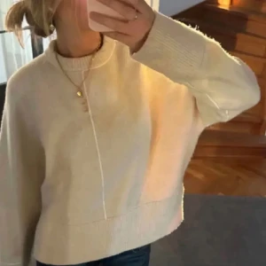 Beige stickad tröja - Supermysig beige stickad tröja med oversized känsla och lång ärm. Tröjan har en bred ribbad kant nertill och vid ärmsluten samt en snygg söm framtill som detalj. Perfekt för lager-på-lager och chill dagar. Säljer då tröjan inte kommit till användning!! 💕💕