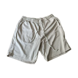 Beige shorts med snörning, storlek L - Snygga beige shorts med elastisk midja och snörning framtill, storlek L 