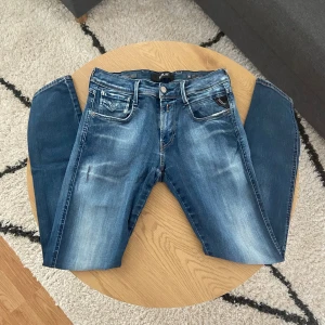 Mörkblåa Replay - Tjena👋 Säljer nu dessa snygga mörkblåa jeans från Replay med klassisk femficksdesign och coola slitningar🔥 Jeansen har raka ben, normal passform och tydliga kontrastsömmar👖Perfekta för dig som gillar en avslappnad men stilren look🙌  Storleken är W30(36cm) L32(100cm)📐  Byxorna är i Anbass modell och har hyperflex material🪡  Vid frågor: Meddela oss!📩
