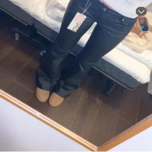 Svarta skinnbyxor från ONLY XS - Snygga svarta bootcut byxor från ONLY i storlek XS. Byxorna har klassisk femficksdesign, normalhög midja och är tillverkade i ett glansigt material som ger en cool look. Perfekta för dig som gillar en trendig och stilren vibe.